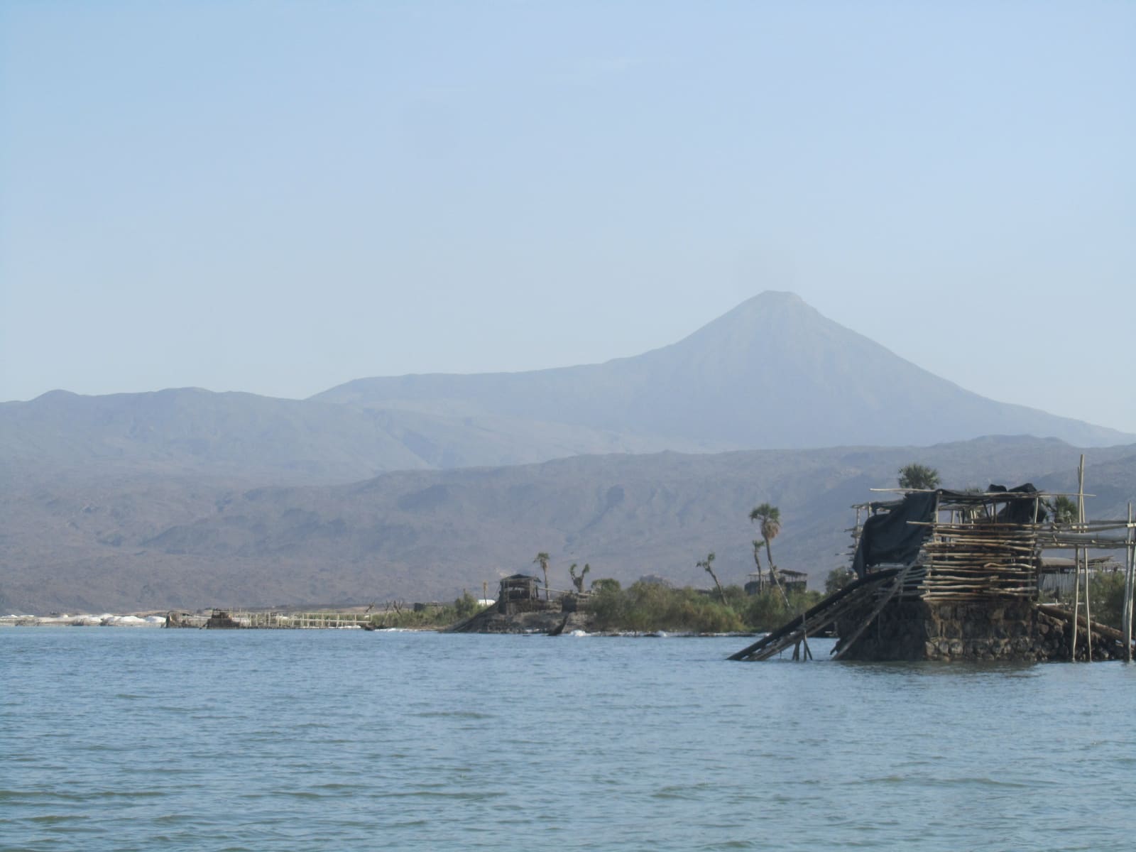 Cono vulcanico che si staglia dietro le acque saline e immobili del lago Afrera