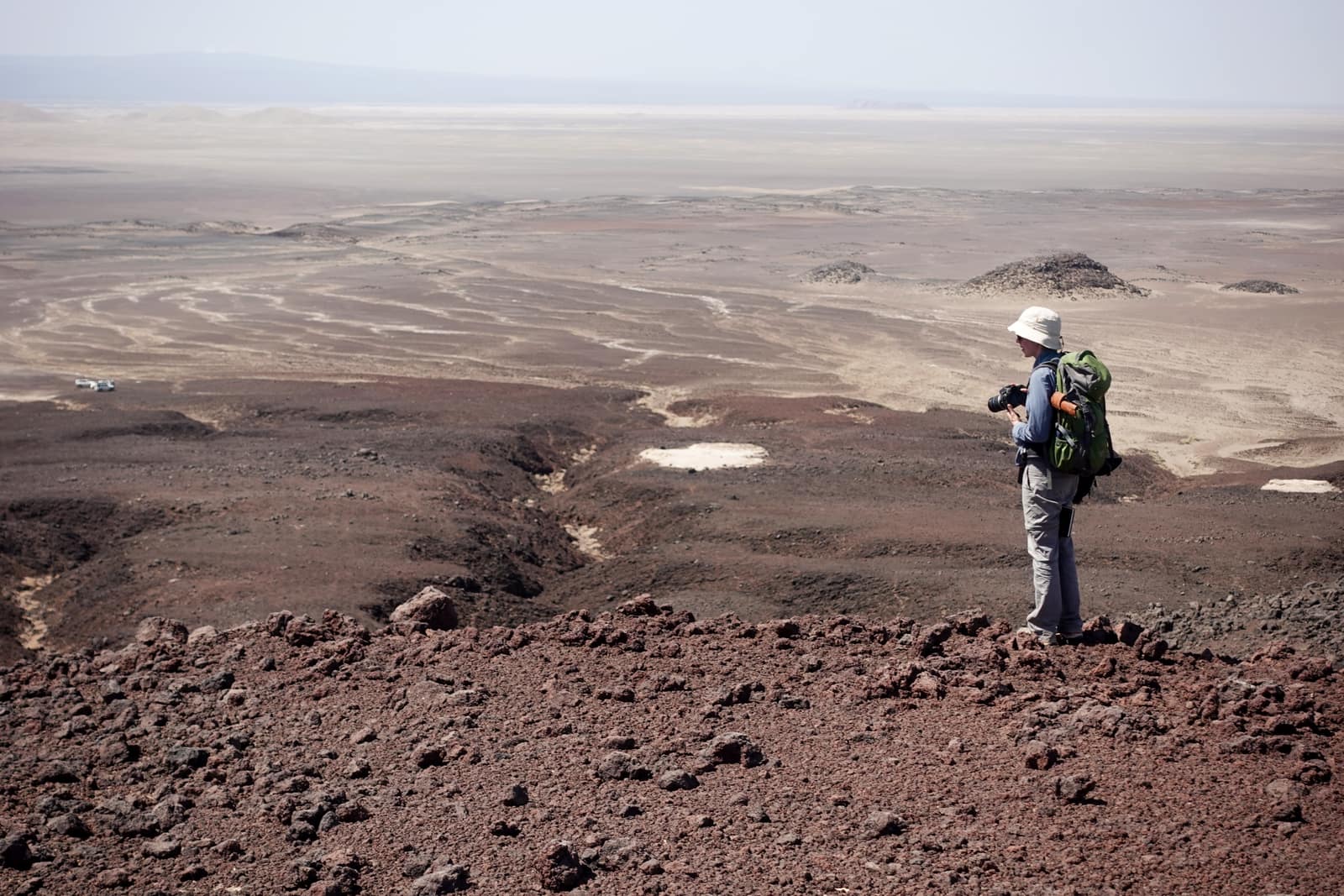 A lone traveller on the empty volcanic plain of the Danakil Depression